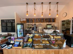 till and glass shelving display of various cakes and pasteries in the Midge Bite Cafe